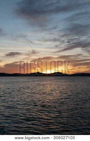 A Delicate Orange And Grey Coloured Stratocumulus Cloudy Coastal Sunrise Seascape In A Blue Sky Over