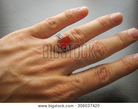 Yemeni Red Aqeeq Agate Stone. Male Hand With Ring On Ring Finger With Dark Background. Yemen Ring. M