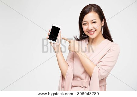 Portrait Of Beautiful Asian Wowan Showing Or Presenting Mobile Phone Application On Hand Isolated Ov