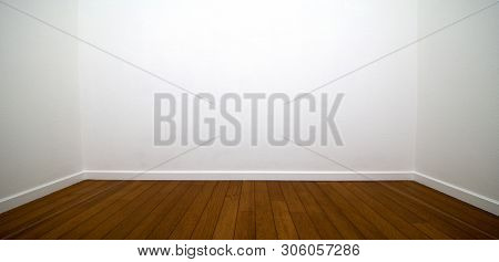 White room. Three walls of a white room with wood flooring and white trims.