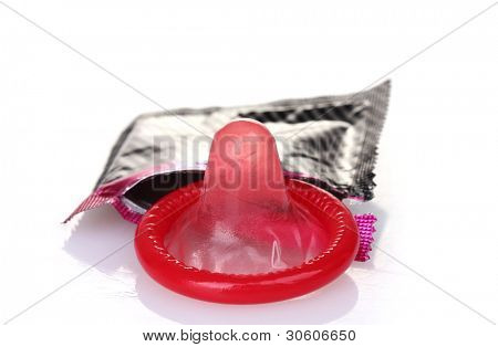 Red condom with  open pack isolated on white