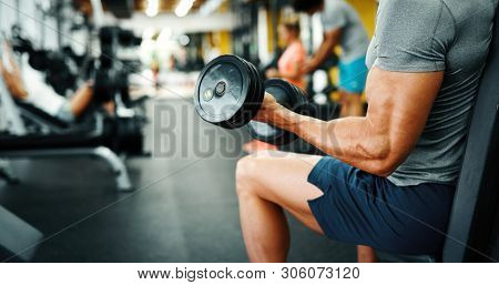 Muscular Bodybuilder Guy Doing Exercises In Gym