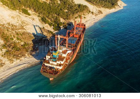 Aerial View Of Cargo Ship Run Aground On Wild Coast, Shipwreck After Storm, Drone Shot
