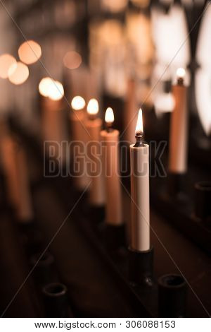 Color Image Of Rows Of Candles Burning In A Church.
