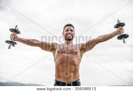 Free Your Mind. Fitness And Sport Equipment. Success. Perfect Biceps. Muscular Man Exercising In Mor
