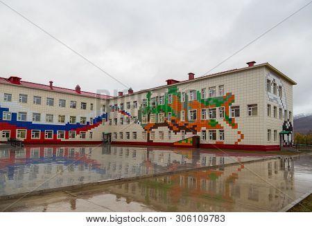 Esso, Kamchatka Peninsula, Russia- 02 October 2014: School Building Exterior With Playground On A We