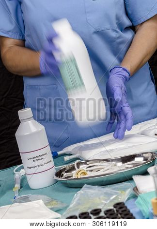 Nurse Shaking Enteral Nutrition Bottle In A Hospital, Palliative Care, Conceptual Image