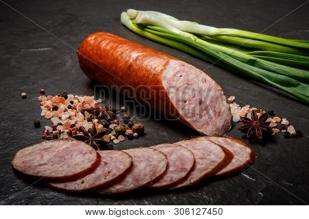 Half Of Smoked Ham Sausage With Sliced Pieces And Green Onions