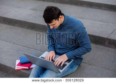 Concetrated Students Using Laptop And Books Learning For Exam R On Campus Stairs. Students Looking F