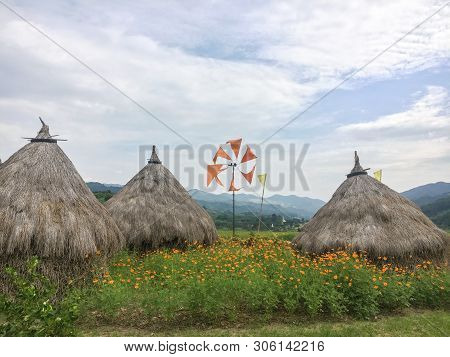Chaff Thatch Orange Wind Mill And Yellow Flower