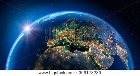 Planet Earth At Night With The Rising Sun With The Light Of Cities Illuminating A Detailed Exaggerat