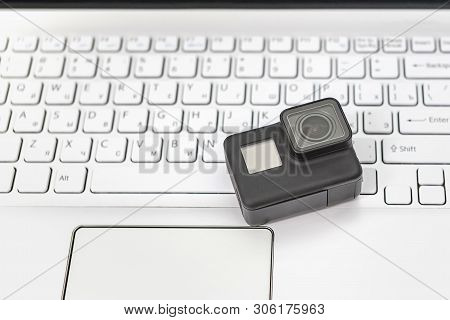 Action-camera On The Background Of A White Laptop Keyboard.