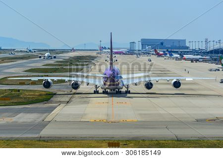 Passenger Airplanes Taxiing On Runway