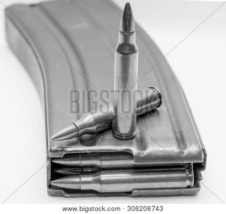 223 Caliber Bullets Loaded Into A Rifle Magazine With Two Additional Bullets Shot In Black And White