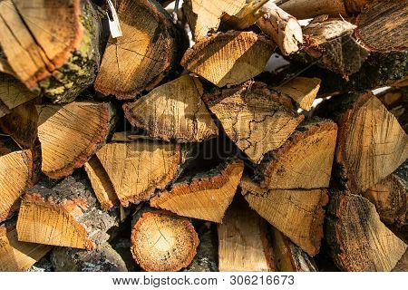 The Wall Is Laid Out With The Ax By The Ax Wood In The Village, The Texture Of Wooden Firewood.