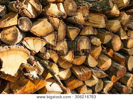 The Wall Is Laid Out With The Ax By The Ax Wood In The Village, The Texture Of Wooden Firewood.