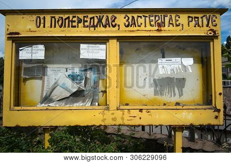 Kropyvnytskyi, Ukraine - July, 2018: Yellow Weathered Bulletin Board. Old Fire Safety Box For Massag