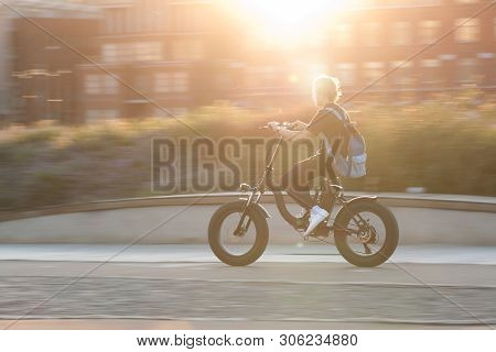 The Guy On A Bicycle Is Driving Around The City On A Sunny Summer Evening