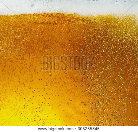 Close Up View Of Floating Bubbles In Light Golden Colored Beer Background. Texture Of Cooling Summer