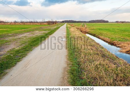 Seemingly Endless Straight Path In A Rural Polder Landscape On A Cloudy Day In The Dutch Winter Seas