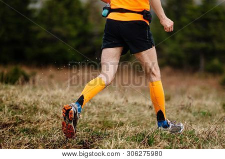 Legs Runner Man In Orange Compression Socks Running On Trail Water Spray