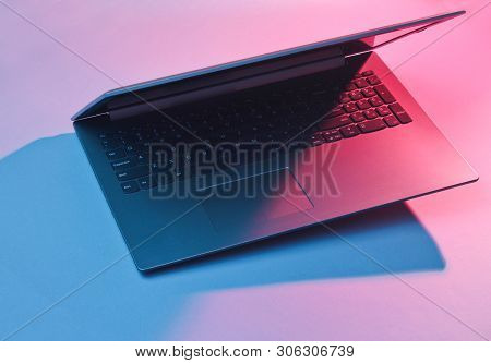 Modern Laptop With Vibrant Gradient Pink  Blue Holographic Color Lights. Minimal Office Surrealism C