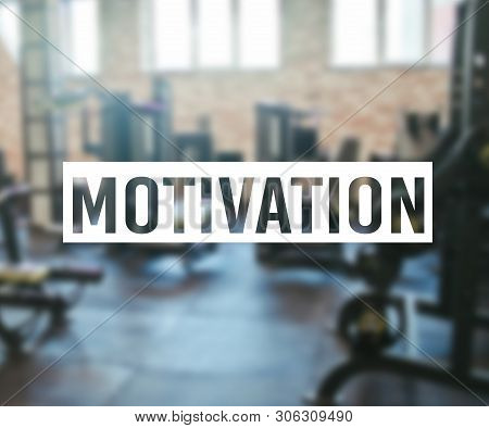 Word Motivation On Blurred Background Of Gym With Equpment.