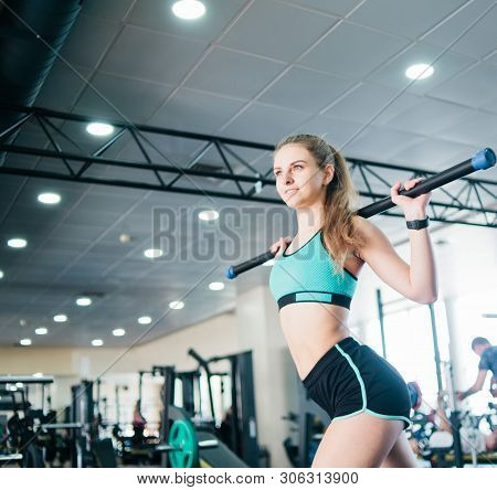 Fitness Young Blonde Woman Doing Gymnastic Exercise With  Body Bar Stick In The Gym
