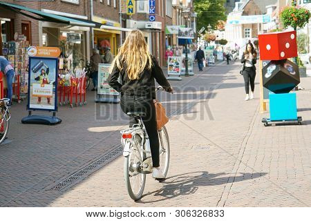 A Girl Rides A Bicycle Along The Street Of The Old City Dorpstraat. 30 August 2018. Zoetermeer. Neth