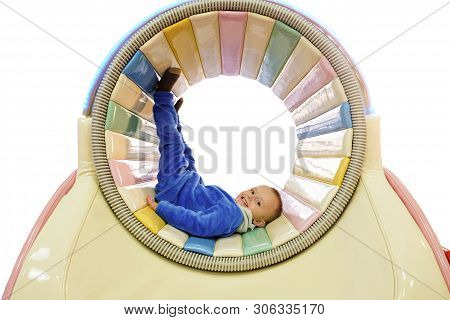 Boy In A Spinning Drum In A Children Play Area. Child Playing In Playground Of Indoors Amusement Par