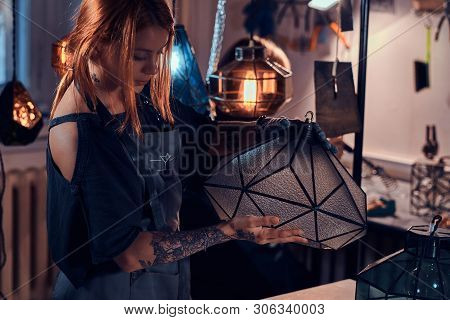 Talanted Young Designer With Tattoo On Her Hand Is Prepearing New Lamp, She Is Holdind It In Hands.
