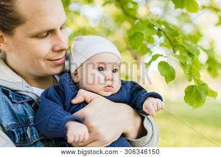 Loving, Happy, Young Father In Jeans Jacket Holding The Beautiful Keen Child In Blue Jacket And Whit