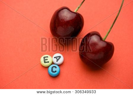Close Up Of Multicolored Letters Indicating The Vitamins A, C, E Contained In Cherries Near The Two 