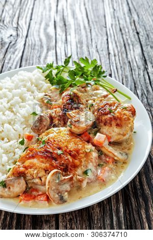 Chicken Stewed With Cream White Wine Sauce, Mushrooms And Vegetables And Served With Rice On A Plate