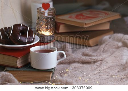 Mug With Tea, Books, Donuts And Woolen Plaid Winter Blanket On Vintage Wooden Table, Autumn Winter S