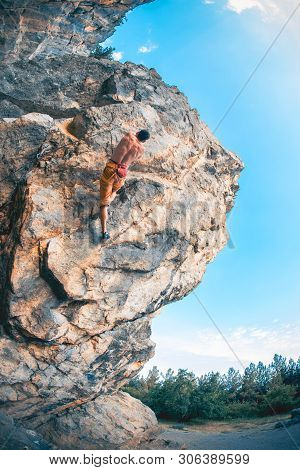 Athletic Man Climbs A Rock, 7c Category Route In The Forest With Rope. Sport Climbing In Crimea, Lea
