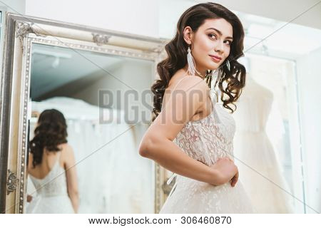 Beautifu bride choosing wedding dress in a wedding salon