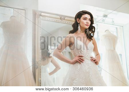 Beautifu bride choosing wedding dress in a wedding salon