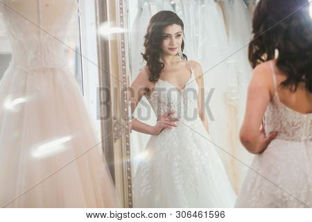 Beautifu bride choosing wedding dress in a wedding salon