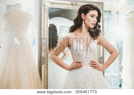 Beautifu bride choosing wedding dress in a wedding salon
