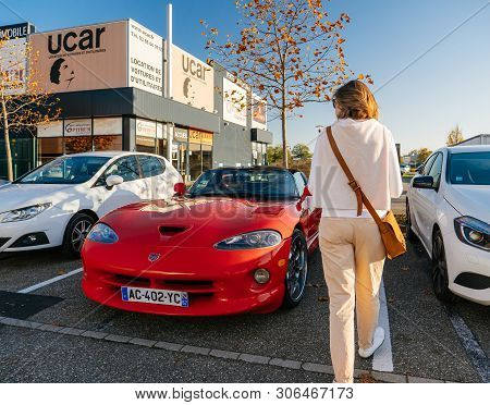 Strasbourg, France - Oct 15, 2017: Rear View Of Young French Woman Walking Near Red Cabriolet Conver
