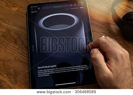 Paris, France - Jun 6, 2019: Man Reading On Apple Ipad Pro Tablet About Powerful Professional Workst