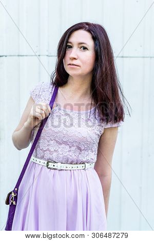 Beaytiful Caucasian Woman In A Purple Summer Dress Standing Outside On White Door Background