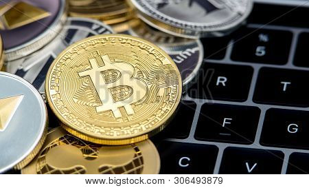 Physical Metal Golden Bitcoin Currency On Notebook Computer Keyboard. Btc