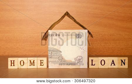 House Made From The Indian Currency Notes And Home Loan In Wooden Block Letters On Wooden Background