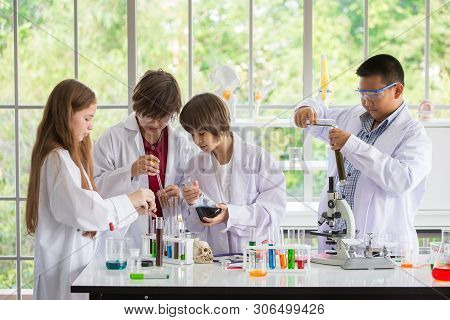 Group Of Pupils In White Gown Doing A Chemical Experiment In Laboratory At School . Kids In Science 
