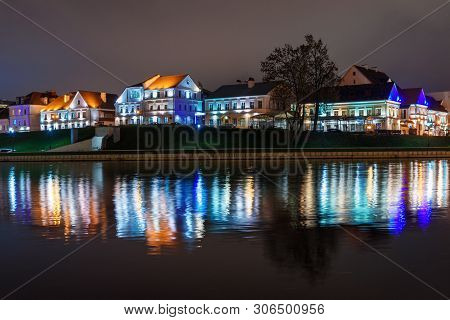 Traetskae Pradmestse Or Trinity Suburb On Svisloch River Bank At Night. Historical Center Of Minsk. 