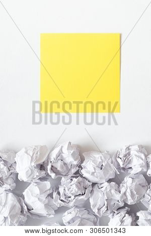 Ideas And Inspiration Concept. Flat Lay Of Crumpled Paper Ball Pile And Yellow Black Note On White B