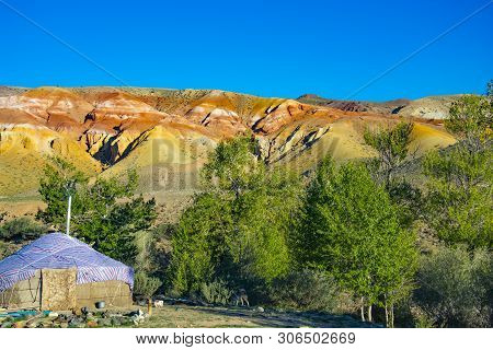 Yurta Is Set Against The Background Of Multi-colored Mountains