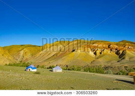 Yurta Is Set Against The Background Of Multi-colored Mountains
